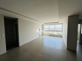 Ambiente interno de uma sala com grande janela voltada para a cidade.