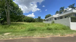 Vista externa de uma casa branca com um grande gramado verde em primeiro plano.