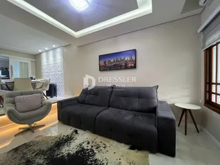 Sala de estar moderna com sofá cinza escuro e decoração contemporânea.
