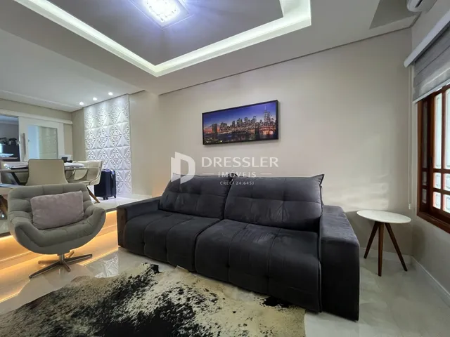 Sala de estar moderna com sofá cinza escuro e decoração contemporânea.