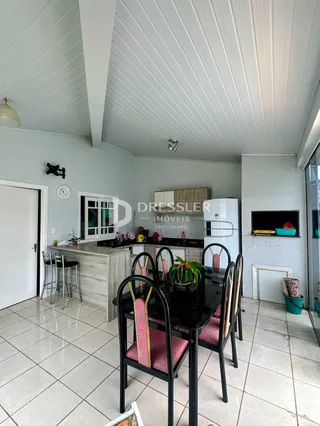 Uma sala de jantar com mesa e cadeiras em um imóvel no Brasil.