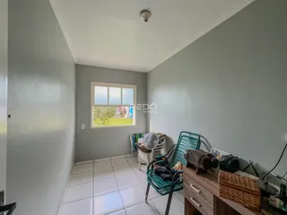 Foto de um corredor interno com janela em uma residência.