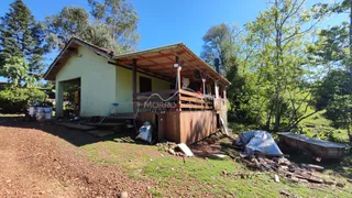 Fachada de uma casa rústica com deck em área verde em Lajeado, Brasil.