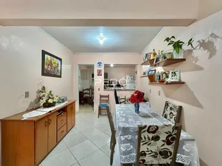 Interior de uma sala de jantar com móveis de madeira e decoração nas paredes.