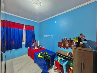 Quarto com paredes azuis e cortinas vermelhas e azuis.