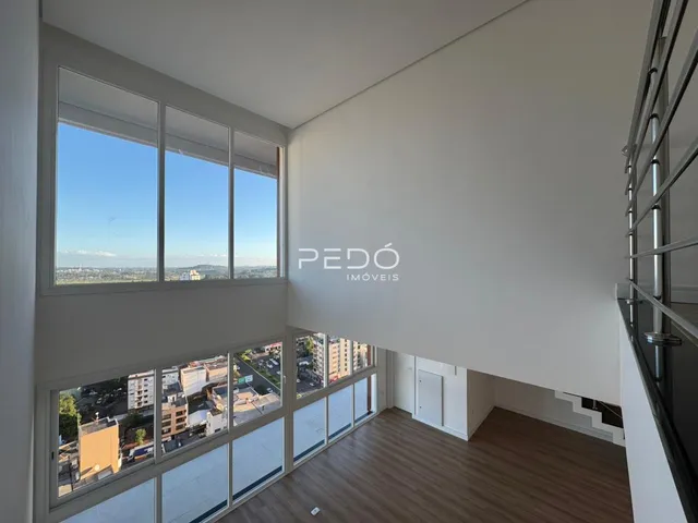 Sala ampla com grandes janelas oferecendo vista da paisagem urbana.