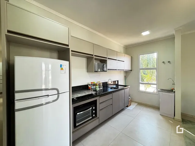 Foto da cozinha com armários e eletrodomésticos em um imóvel no Brasil.