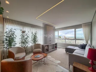 Sala de estar iluminada com grandes janelas que oferecem uma vista panorâmica.