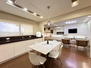 Uma sala de jantar com mesa e cadeiras brancas em um ambiente claro.