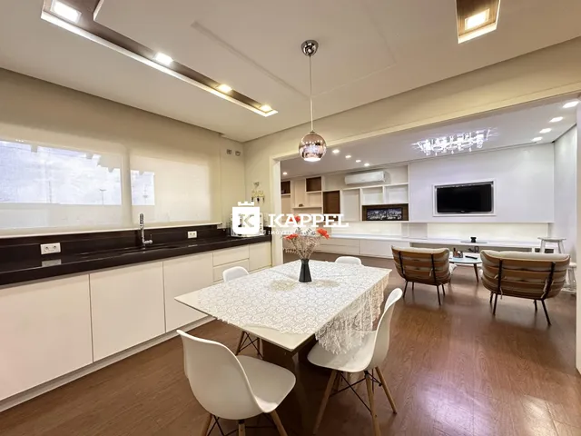 Uma sala de jantar com mesa e cadeiras brancas em um ambiente claro.