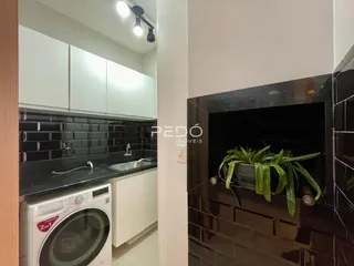 Uma cozinha com armários brancos e revestimento preto.