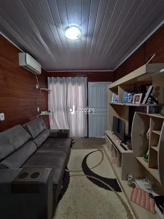 Sala de estar com sofá e estante de madeira na residência.