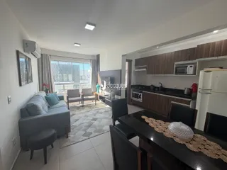 Sala de estar com vista para o exterior e cozinha integrada.