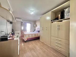 Um quarto com armários embutidos e piso de madeira clara.