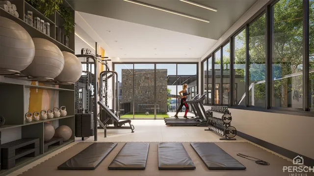 Foto de uma sala de ginástica moderna com equipamentos de musculação e grandes janelas.