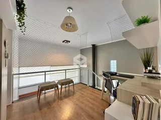 Sala de estar com piso de madeira e teto inclinado.