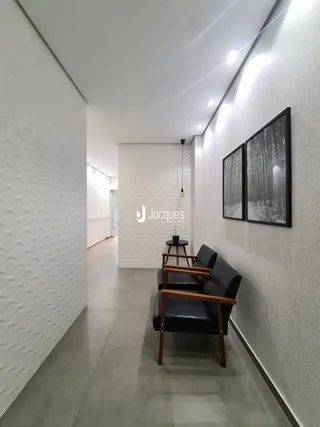 Corredor interno branco com piso cinza claro.