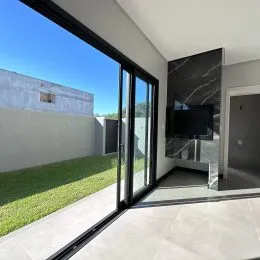 Vista externa através de portas de vidro que dão acesso a um gramado.