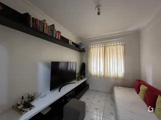Quarto com janela e televisão montada na parede.