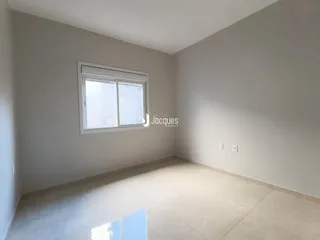 Ambiente interno de uma sala com piso de cerâmica e janela.