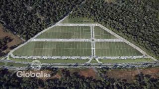 Vista aérea de um campo gramado cercado por vegetação.