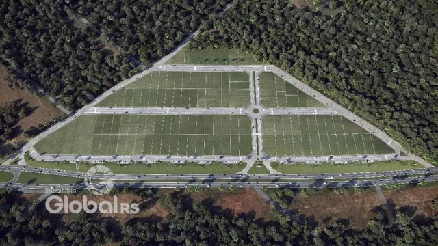 Vista aérea de um campo gramado cercado por vegetação.