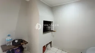 Vista interna de um ambiente com paredes brancas e uma área de nicho.