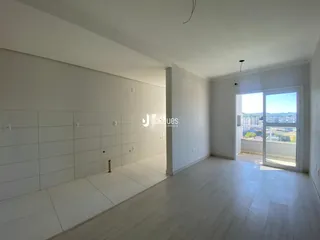 Ambiente interno de uma sala ampla com piso claro e paredes brancas.
