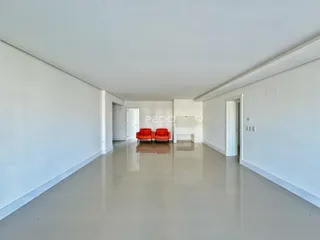Sala de estar ampla com paredes brancas e piso claro.