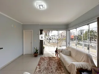 Sala de estar com sofá claro e piso de cerâmica em um imóvel em Lajeado.