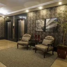 Foto de uma sala de estar com paredes decoradas e estofados.