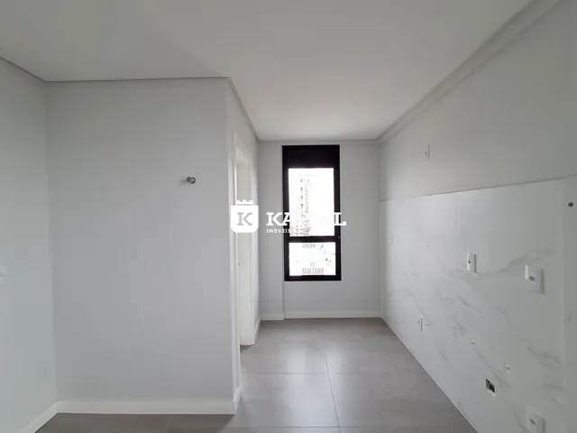Hall de entrada com paredes brancas e piso claro, apresentando uma área de passagem.