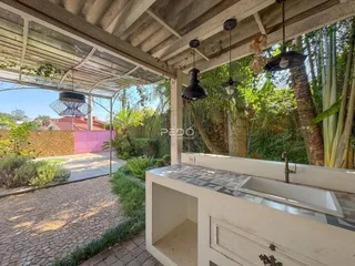 Vista de uma área externa coberta com piso de tijolos e jardim em Lajeado, Brasil.