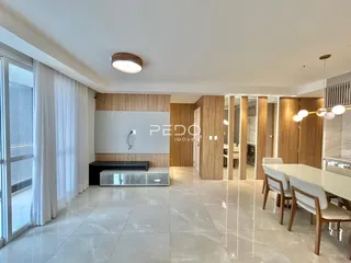 Vista de uma sala de estar moderna com piso de mármore claro e painéis de madeira.
