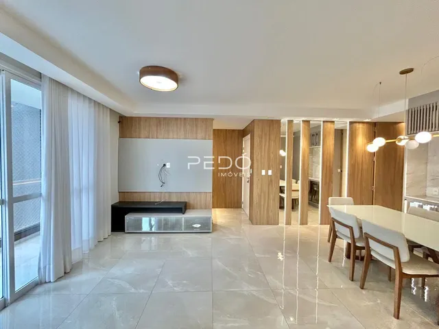 Vista de uma sala de estar moderna com piso de mármore claro e painéis de madeira.