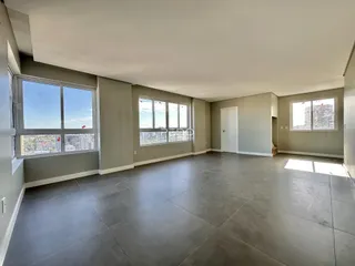 Sala ampla com grandes janelas que oferecem vista da cidade.