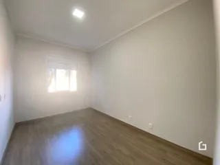 Ambiente interno com piso de madeira clara e paredes brancas.