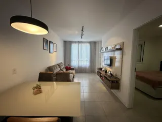Sala de estar com sofá e mesa de jantar em um apartamento.