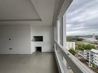 Espaço interno com paredes brancas e piso de concreto.