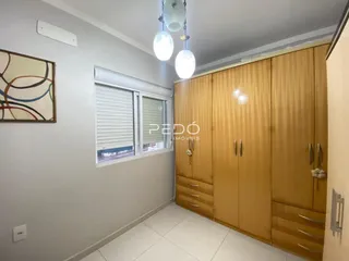 Quarto com armário em madeira e piso claro.