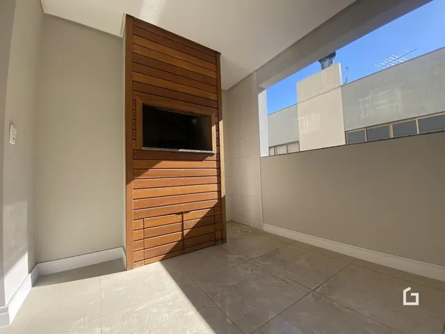 Interior de um ambiente com parede de madeira e vista para o exterior.