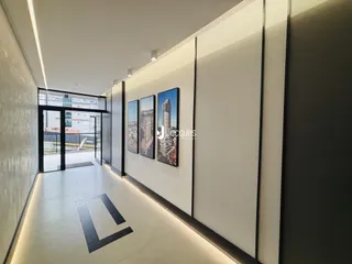 Corredor interno de um imóvel moderno com paredes brancas e piso claro.