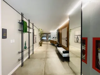 Hall de entrada moderno com paredes brancas e piso claro.