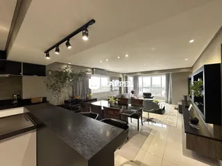 Foto de um ambiente interno moderno com ilha central e iluminação clara.
