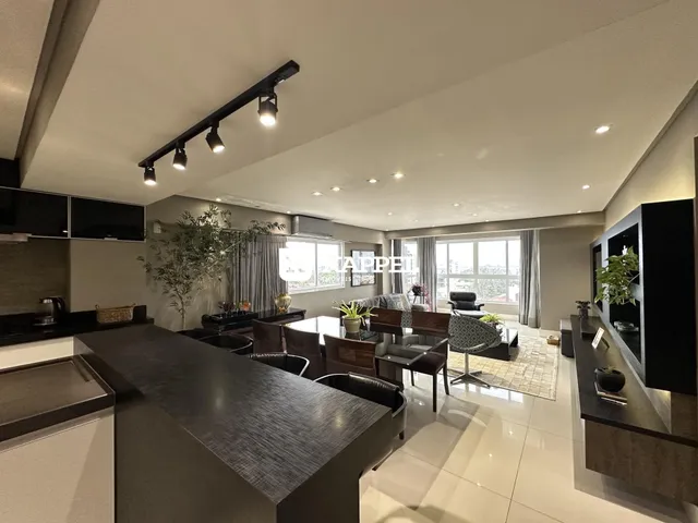 Foto de um ambiente interno moderno com ilha central e iluminação clara.