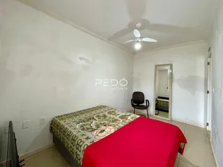 Quarto com cama e espelho na parede branca.