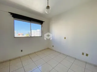 Ambiente interno de uma sala com piso de cerâmica e janela.