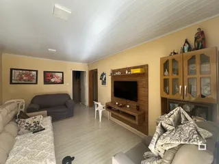 Sala de estar com sofá e painel de madeira em um imóvel no Brasil.