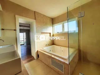 Foto de um banheiro com banheira e box de vidro.