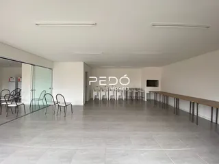 Interior de uma sala ampla com piso de cerâmica e armários embutidos.